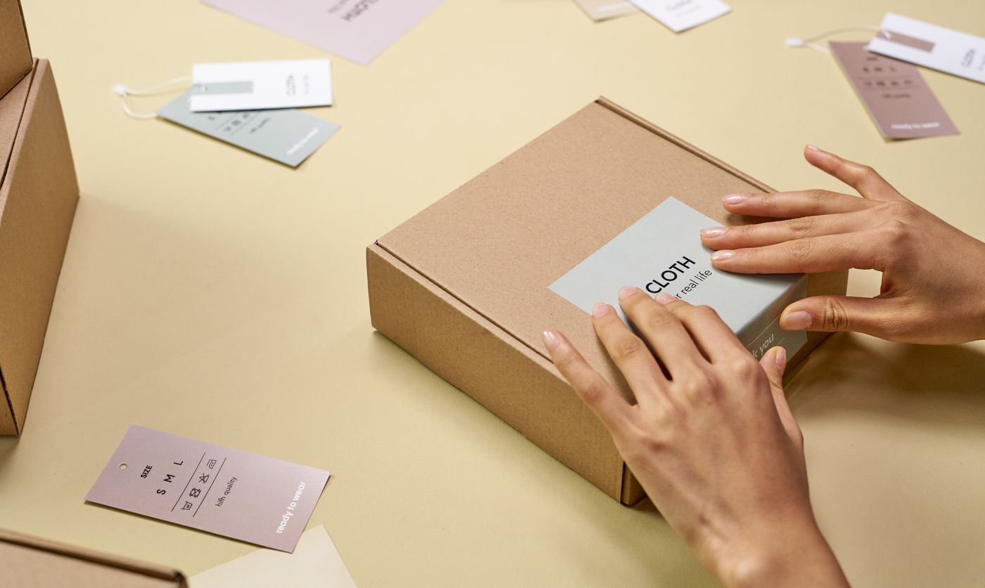 Hands applying a product label to custom packaging